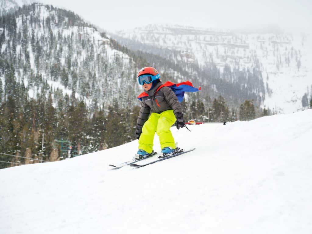 Power kid skiing down a trail